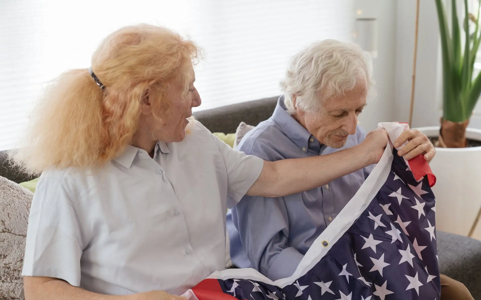 Senior couple holding an American flag — VA Aid and Attendance benefits for veterans